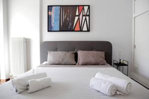 Charming apartment near center في أثينا: غرفة نوم عليها سرير وفوط