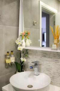 uma casa de banho com um lavatório branco e um espelho. em Luxury Apartments 'Rich' em Velingrad