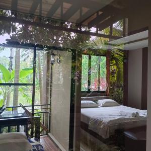 a bedroom with a bed and a large window at สวนผึ้ง2 รีสอร์ท - Suan Phueng 2 Resort in Bang Sare