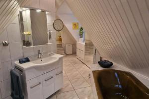 a bathroom with a sink and a bath tub at Stadtnahe Familienvilla in Oersdorf +26 photos