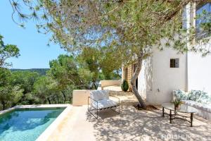 a patio with a pool and a chair and a table at Casablanca in Ses Salines