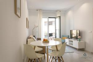 uma sala de estar com mesa e cadeiras em Living4malaga Blue Bay em Málaga