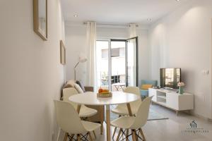 sala de estar con mesa y sillas en Living4malaga Blue Bay, en Málaga