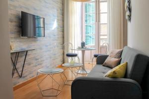 salon z kanapą i telewizorem na ścianie w obiekcie Living4malaga Spring Boutique w Maladze
