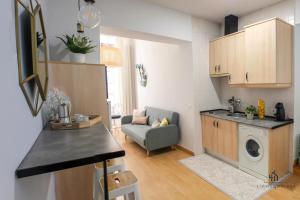a kitchen and living room with a couch and a washing machine at Living4malaga Spring Boutique in Málaga