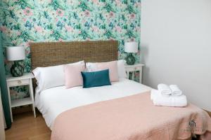 sypialnia z dużym łóżkiem i tapetą w kwiaty w obiekcie Living4malaga Spring Boutique w Maladze