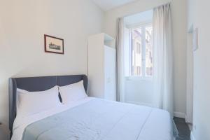 a white bed in a white bedroom with a window at Prefetti 46 in Rome