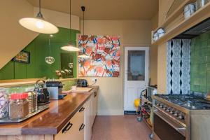a kitchen with green walls and a counter top at Folkestone Terrace - quirky vibe holiday home in Kent