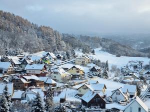 uma pequena cidade coberta de neve com casas em Landhaus Talblick- Boutique B&B-Pension-Gästehaus em Brotterode