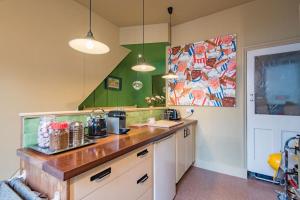 a kitchen with a wooden counter top and green walls at Folkestone Terrace - quirky vibe holiday home in Kent +20 photos