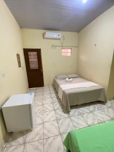 1 dormitorio con 1 cama y suelo de baldosa en Aconchego da Vó, en Barreirinhas