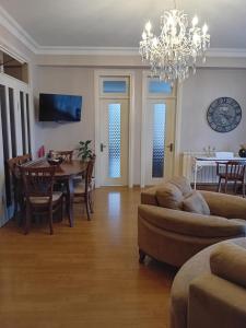 uma sala de estar com uma mesa e um lustre em Apartment Chavchavadze 21 em Batumi