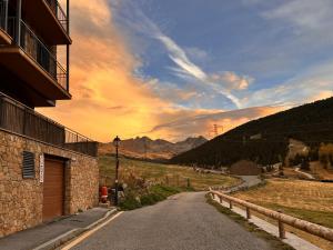 une route vide avec un coucher de soleil dans les montagnes dans l'établissement Prat de Baix Bordas d'Envalira, à Bordes d´Envalira 