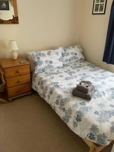 un dormitorio con una cama con un animal de peluche en Cosy terrace cottage built into the mountain side. en Blaenau-Ffestiniog