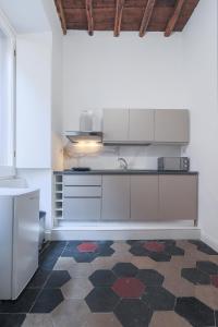 a kitchen with white cabinets and a checkered floor at Prefetti 46 in Rome