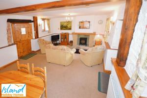 a living room with couches and a fireplace at The Stables in Saint Helens