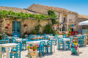 イスピカにあるVilla Pinella by Villa Plusの建物の前に屋外パティオ(テーブル、椅子付)