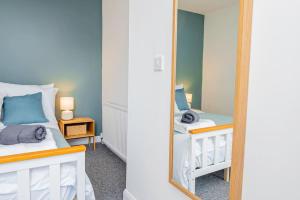 a mirror in a small room with a bed at Ground Floor Apartment with Free WIFI and Parking in Oxford