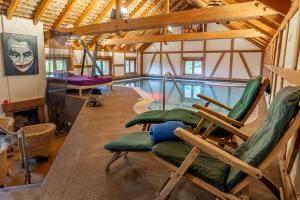ル・ホーヴァルトにあるLe Chalet du Hohwald- Piscine Intérieure chauffée - Proche Champ du Feuのスイミングプールと椅子2脚付きの家