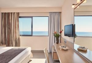 Pokój hotelowy z łóżkiem i biurkiem z telewizorem w obiekcie Atlantica Mikri Poli Crete w mieście Makry Gialos