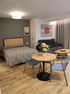 1 dormitorio con 1 cama, mesa y sillas en Apartamentos Leonor, en Málaga