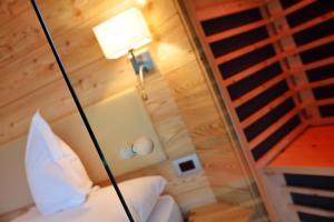 Zimmer mit einem Bett mit einer Lampe und einer Treppe in der Unterkunft Chalet Elisabeth dolomites alpin & charme in Wolkenstein in Gröden
