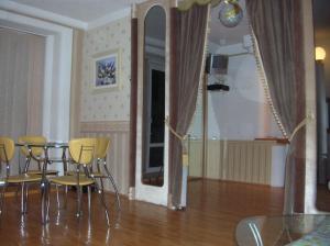 een eetkamer met een tafel en stoelen en een spiegel bij Apartments Arhitektora Artynova in Vinnytsya