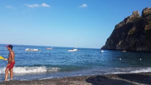a man standing on a beach with a frisbee at SANT'ALESSIO_BAY in Santa Margherita-Sant'Alessio Siculo