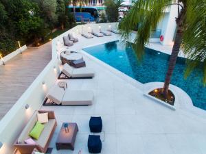 托隆的住宿－Flisvos Royal，享有带躺椅和棕榈树的游泳池的顶部景致