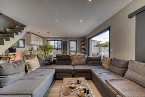 a living room with a large couch and a staircase at Maison Melgorienne in Mauguio