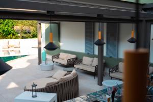 托隆的住宿－Flisvos Royal，一个带沙发和椅子的庭院和一个游泳池