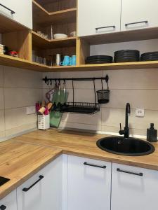una cucina con armadi bianchi e lavandino di Apartman PLAY Divčibare - 2 spavaće sobe a Divčibare Altre 29 foto