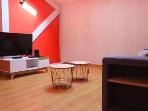 a living room with two stools and a flat screen tv at Gîte Remiremont, 4 pièces, 6 personnes - FR-1-589-411 in Remiremont