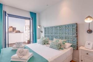 een slaapkamer met een groot bed met blauwe en groene kussens bij Hotel & Spa La Residencia Puerto in Tarifa