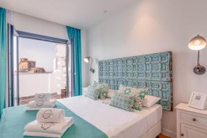 una camera da letto con un grande letto con cuscini blu e verdi di Hotel & Spa La Residencia Puerto a Tarifa