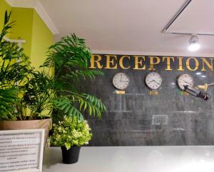 a group of clocks on a wall with the word reception at Отель Бестау in Aksay