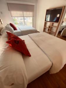 a bedroom with two beds and a flat screen tv at Apart Hotel Rio Grande in Rosario