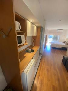 a small kitchen with a sink and a bedroom at Apart Hotel Rio Grande in Rosario +54 photos
