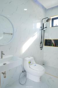 a white bathroom with a toilet and a sink at F&F pool villa Rayong in Rayong