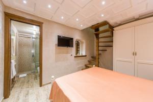 a bedroom with a bed and a tv on the wall at B&B La Casa Nel Giardino in Piano di Sorrento
