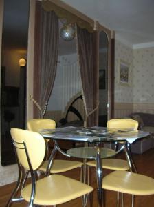 een tafel met gele stoelen en een eetkamer bij Apartments Arhitektora Artynova in Vinnytsya