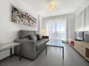 a living room with a couch and a tv at Apartamentos Hipocampos Calpe Rent Apart in Calpe