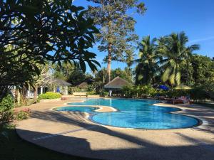 a swimming pool in a resort with palm trees at Suan Bankrut Beach Resort in Ban Krut