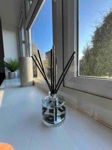 a vase with sticks in it on a window sill at Modern Apt - Comfort Family and Business Travellers with Parking in Oxford