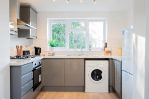 een keuken met een wasmachine onder de gootsteen bij Modern Apt - Comfort Family and Business Travellers with Parking in Oxford