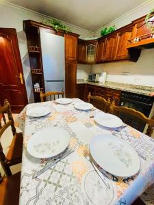 uma cozinha com uma mesa com pratos em Casa Paradela Sanxenxo em Pontevedra