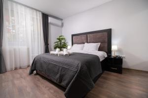 a bedroom with a large bed with a plant on it at Chic 1BR Apartment with Balcony in Plovdiv in Plovdiv
