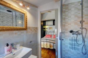 baño con lavabo y ducha con cama en Apartment Etta, en Fažana