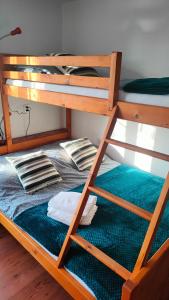 ein Etagenbett mit grüner Bettwäsche und Kissen darauf in der Unterkunft Pokoje Na Brzegu 
