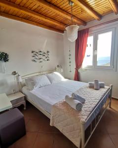 a bedroom with a large bed with towels on it at Maroussa's Apartments in Rámos